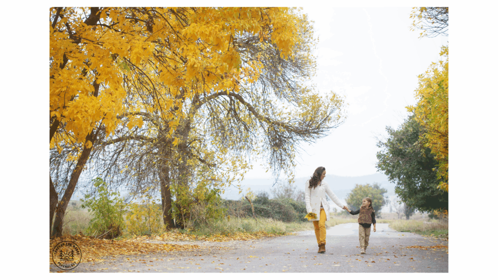 “Parent and child walking hand-in-hand under golden fall leaves in Calgary, Alberta.”